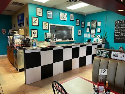 Inside Nate's Diner Houston — counter view with black and white checker pattern and teal walls